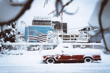 A red truck covered in snow that needs to be prepared for winter. Find tips here at Andys Auto Wash.